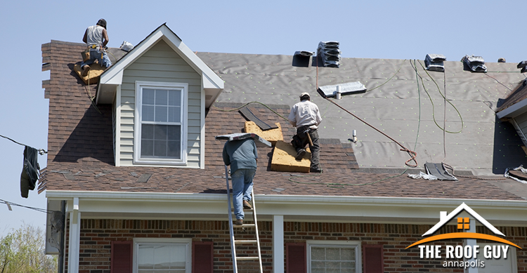 Crew of roofers completing a roof replacement.